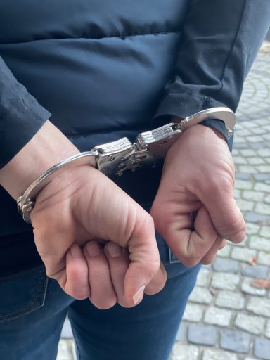 Angelegte Handschellen auf dem Rücken eines inhaftierten