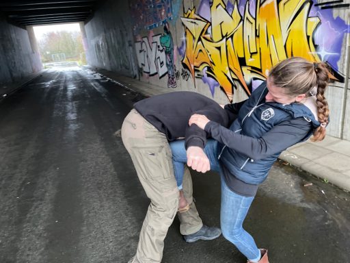 Eine Frau verteidigt sich mit einem gezielten Tritt gegen einen Angreifer