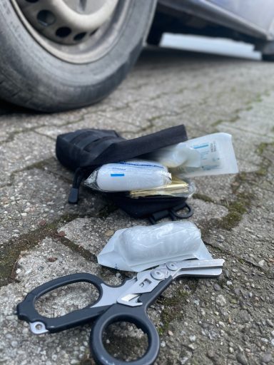 Verbandmaterial und eine Schere liegen auf dem Boden