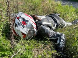 Ein Verletztendarsteller simuliert einen bewusstlosen Motorradfahrer