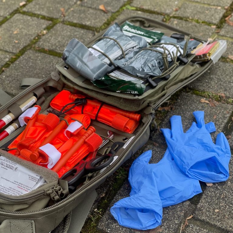 IFAK Training Ein geöffnetes IFAK liegt auf dem Boden daneben benutzte Untersuchungshandschuhe