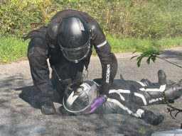 Motorradfahrer am Boden Ein Motorradfahrer liegt am Boden und wird von einem zweiten untersucht