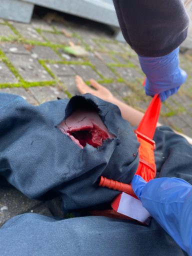 Tourniquet Anlage an einem Dummy mit einer großen Schnittverletzung 
