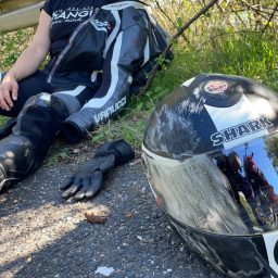 Ersteindruck Simulation Unfall Der sichtbare Ersteindruck eines Motorradunfall bei einer Übung. Ein Biker lehnt an der Leitplanke. Ein verkratzter Helm im Vordergrund